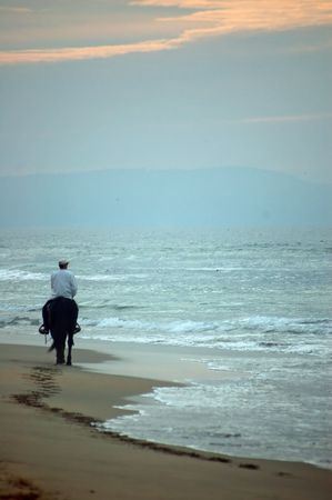 riding into the sunset on the beachの写真素材