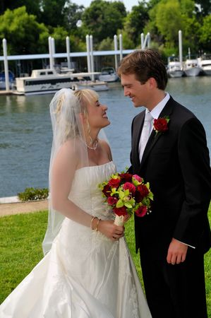 bride and groom on the lawn after their wedding gazing intently into each others eyesの写真素材