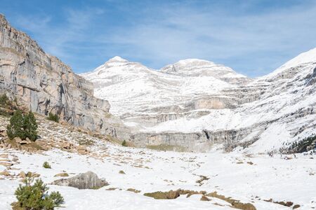 A snowy valley with a mountain in the background.の写真素材