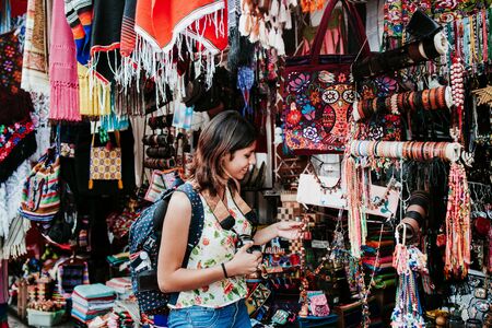 Hispanic woman backpacker buying souvenirs in a traditional Mexican Market in Mexico, Vacationsの写真素材