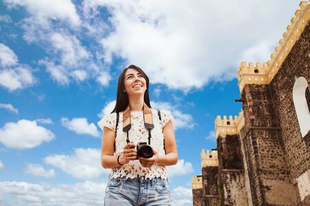 Traveling Latin Woman tourist backpackers holding a camera photo in Mexico cityの写真素材