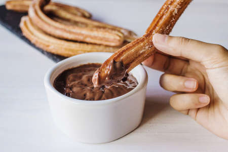 holding Churros with Chocolate, traditional food in Spainの写真素材
