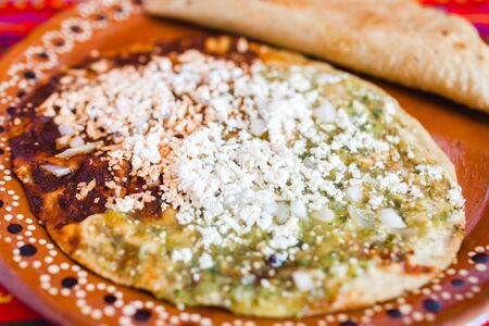 Mexican sopes with grated cheese and green salsa, mexican food spicy in mexicoの写真素材