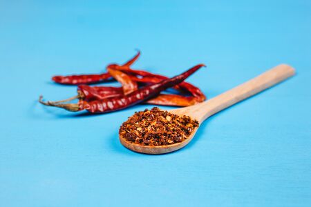 Dried red chili peppers and chili powder spice on blue background in Mexico