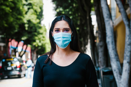 portrait of Mexican business woman with face mask in the streets in a colonial city of Latin America for coronavirus pandemicの写真素材