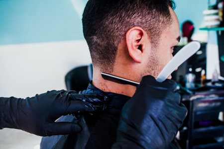 latin Barber Shop, Mexican barber cutting hair with a clipper machine or razor in Mexico Cityの写真素材
