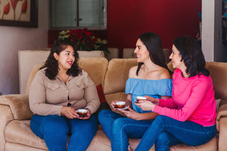 Latin women friends hanging out and drinking coffee in home in Mexico cityの写真素材