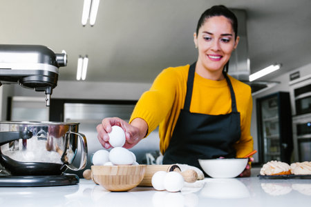 Latin Woman standing in kitchen and kneading dough to bake Conchas traditional Mexican bread