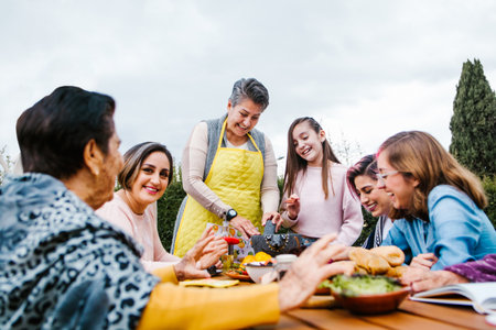 latin grandmother and granddaughter, daughter cooking mexican food at home, three generations of...