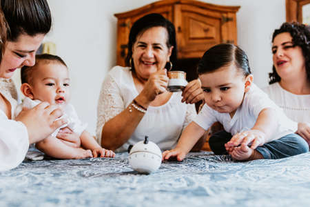 latin grandmother with grandchildren sitting on couch spending time together at home in Mexico city