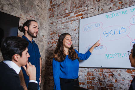 Young latin business girl making presentation using the whiteboard for the work teamの写真素材
