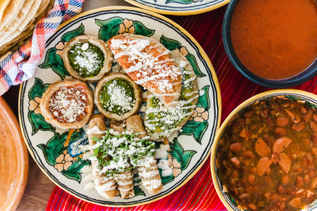 Tacos dorados with chicken and sopes with red and green sauce, frijoles charros, spicy red sauce,...