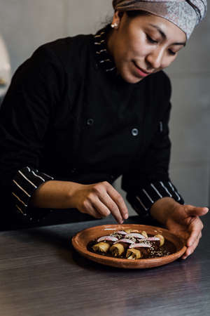 mexican woman cooking mole poblano enchiladas traditional food in a restaurant in Mexicoの写真素材