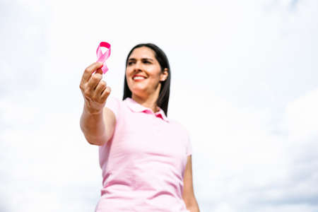 portrait of hispanic woman hand holding pink breast cancer awareness ribbons in Mexico Latin Americaの写真素材