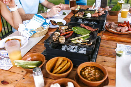 latin people eating Mexican food, Tacos, spicy salsa, tortillas, beer, snacks and peoples hands over...