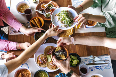 group of Friend eating Mexican Tacos and traditional food, snacks and peoples hands over table, top view. Mexican cuisineの写真素材