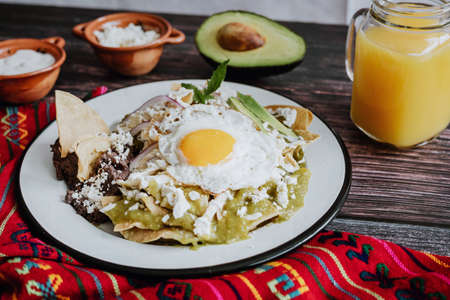 mexican chilaquiles with fried egg, chicken and spicy green sauce traditional breakfast in Mexicoの写真素材