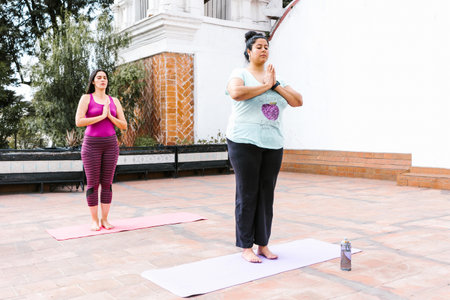 Plus size latin girl meditating with closed eyes standing in outdoor yoga class in Latin Americaの写真素材