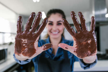 young latin woman with mexican chocolate in hands in process of preparing delicious sweets chocolates at kitchen in Mexico Latin Americaの写真素材
