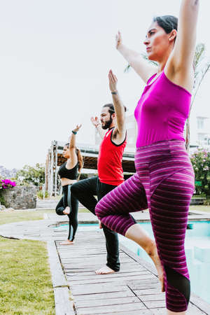 Group of latin people practicing yoga poses standing outdoors in Latin Americaの写真素材