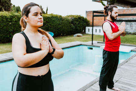 Young hispanic people practicing yoga meditation at home in Latin Americaの写真素材