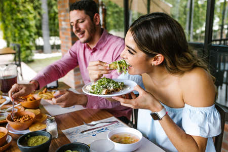 Group of latin friends eating mexican food in a restaurant terrace in Mexico Latin Americaの写真素材