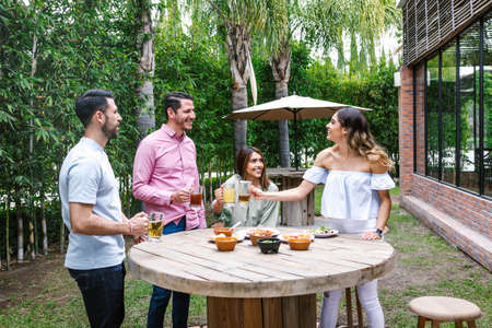 Group of Young latin Friends Meeting For beer, michelada Drinks And mexican Food Making A Toast In Restaurant terrace in Mexico Latin Americaの写真素材