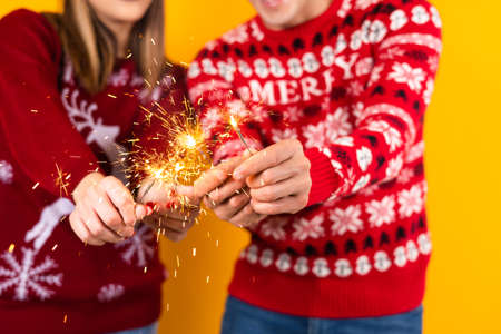 couple of young latin friends having fun with sparklers for Christmas party in Mexico latin americaの写真素材