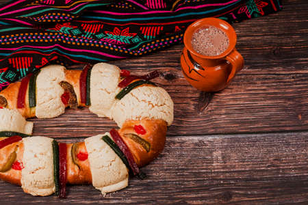 Rosca de reyes or Epiphany cake and clay mug of mexican hot chocolate on a wooden table in Mexico Latin Americaの写真素材