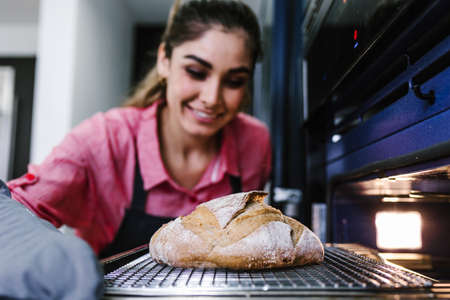 young Latin woman baking bread and ingredients in kitchen in Mexico Latin Americaの写真素材