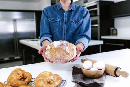 young Latin woman baking bread and ingredients in kitchen in Mexico Latin America