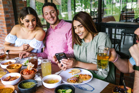 Group of Latin friends eating Mexican food in the restaurant terrace in Mexico Latin Americaの写真素材