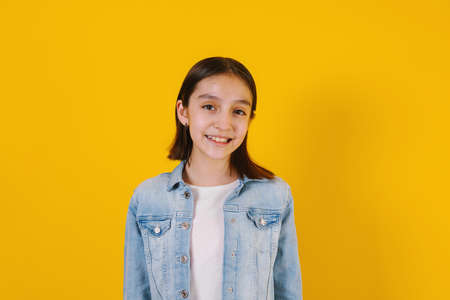 Portrait of latin child girl on yellow background in Mexico Latin Americaの写真素材