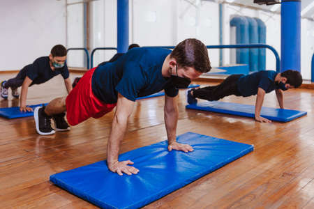 Latin teenagers doing exercise and planks work out with face mask for virus pandemic, Mexico Latin...