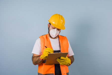 Hispanic man Professional engineering and worker with helmet and face mask for coronavirus pandemic in Mexico Latin Americaの写真素材