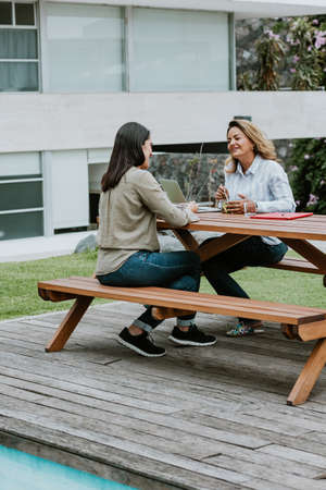Latin business women middle age and colleagues eating salad at the office terrace in Mexico Latin Americaの写真素材