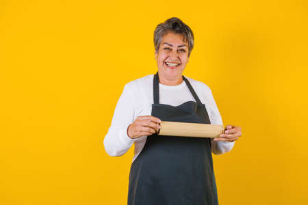 Portrait of hispanic matured woman middle aged cooking and holding mexican plate with sauce ingredients in Mexico Latin Americaの写真素材
