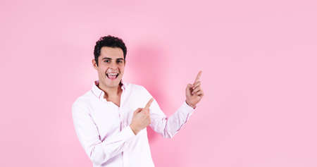 young hispanic business man wearing formal clothes pointing to copy space on pink background in Mexico Latin Americaの写真素材