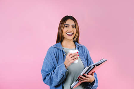 young hispanic business or student woman smiling at camera on pink background in Mexico Latin Americaの写真素材