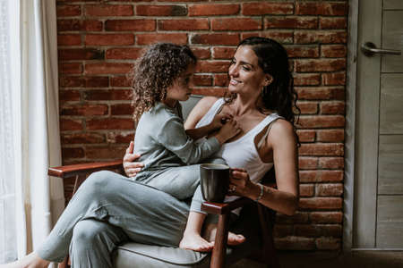 Portrait of hispanic mother and daughter having fun at home in Mexico Latin Americaの写真素材