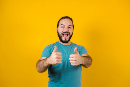 Young hispanic man portrait on yellow background in Mexico Latin Americaの写真素材