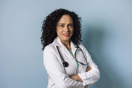 hispanic doctor woman portrait with copy space over blue background laughing in Mexico Latin Americaの写真素材