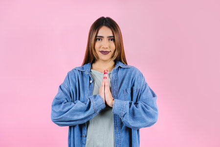 Young latin woman practicing breathing or meditating or yoga class on pink background in Mexico Latin Americaの写真素材