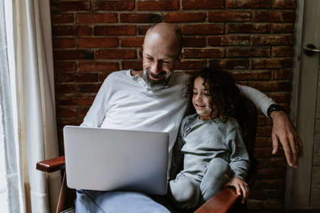 Portrait of hispanic father and daughter working with computer at home office in Mexico Latin Americaの写真素材