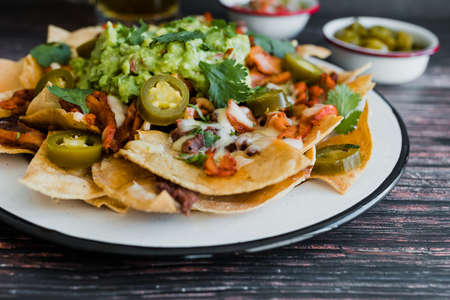 Mexican nachos with guacamole and salsa on wooden backgroundの写真素材