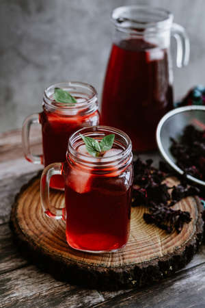 Red Hibiscus tea in a glass mug on a wooden backgroundの写真素材