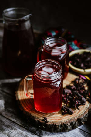 Red Hibiscus tea in a glass jar on a wooden backgroundの写真素材