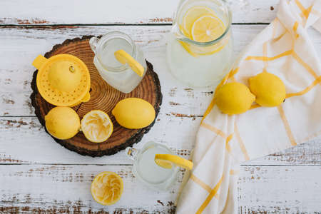 Lemonade with lemons on a white wooden background. Lemonade in a glass jug.の写真素材
