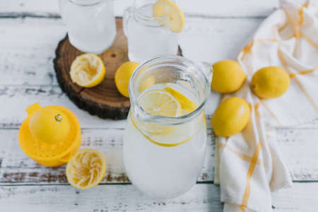 Homemade lemonade with fresh lemons on a white wooden backgroundの写真素材