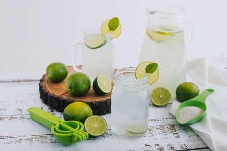 Lemonade with lime and mint in a glass jar on a white wooden backgroundの写真素材